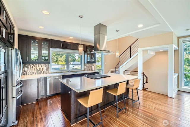 9544 3rd Ave NW, Seattle, WA 98117 - kitchen with stainless steel appliances, decorative backsplash, light countertops, a center island, and a breakfast bar