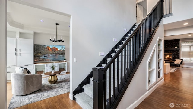 23728 135th Pl SE, Kent, WA 98042 - stairway featuring a large fireplace, wood finished floors, recessed lighting, a chandelier, and a tray ceiling