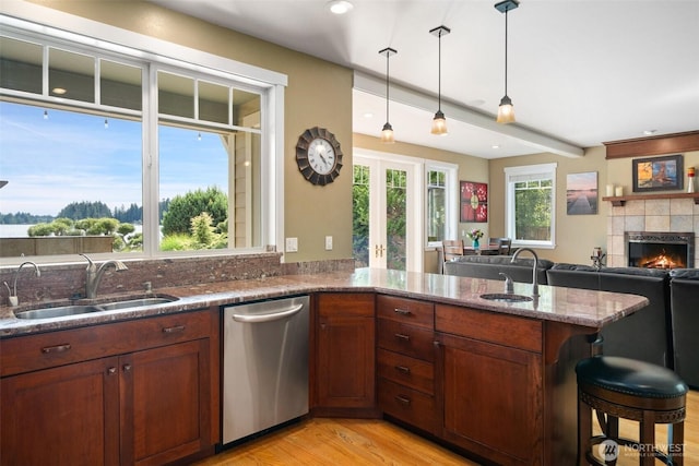 102 E Gibler Ln, Shelton, WA 98584 - kitchen with dishwasher, stone counters, light wood finished floors, decorative light fixtures, and a tiled fireplace