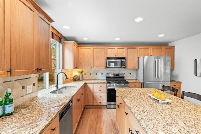 22418 SE 281st St, Maple Valley, WA 98038 - kitchen with appliances with stainless steel finishes, light stone counters, decorative backsplash, light wood-type flooring, and recessed lighting