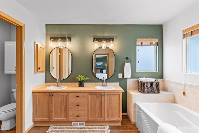 22418 SE 281st St, Maple Valley, WA 98038 - bathroom featuring wood finished floors, healthy amount of natural light, a bath, and double vanity
