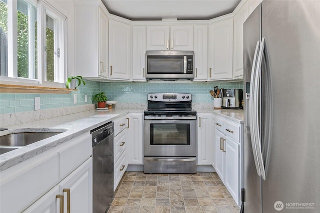 3041 S 201st St, Seatac, WA 98198 - kitchen with stainless steel appliances, white cabinetry, decorative backsplash, and stone finish flooring