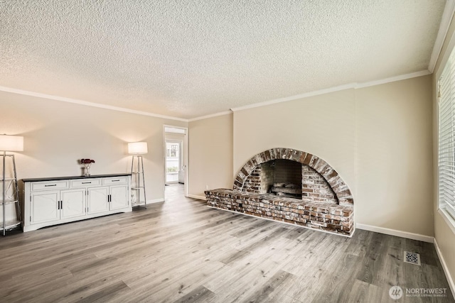 202 Elma Pl SE, Renton, WA 98059 - unfurnished living room with a textured ceiling, wood finished floors, crown molding, and a brick fireplace