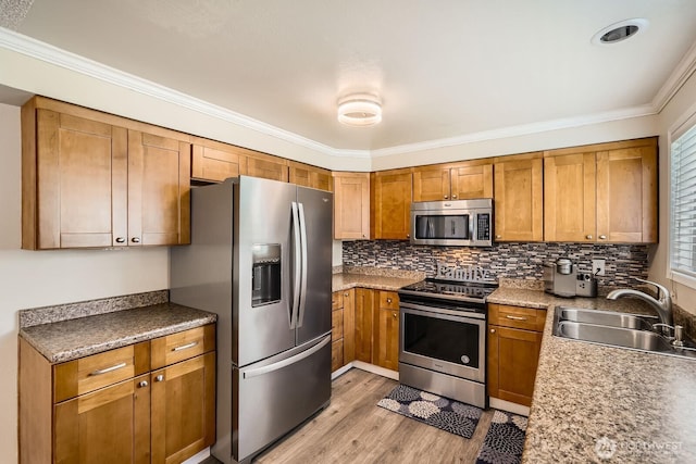 202 Elma Pl SE, Renton, WA 98059 - kitchen with stainless steel appliances, ornamental molding, brown cabinets, light wood-type flooring, and decorative backsplash