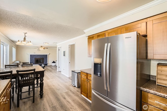 202 Elma Pl SE, Renton, WA 98059 - kitchen featuring stainless steel fridge with ice dispenser, ornamental molding, a brick fireplace, light wood-type flooring, and a ceiling fan