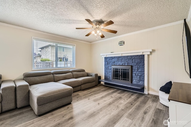 202 Elma Pl SE, Renton, WA 98059 - living area with ceiling fan, a textured ceiling, light wood-type flooring, crown molding, and a fireplace