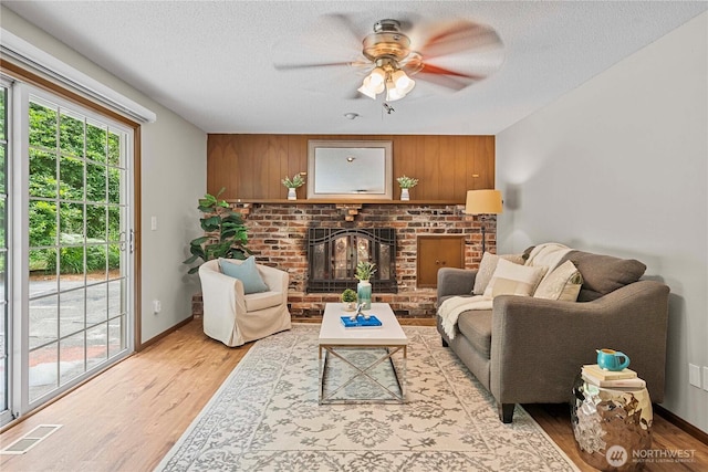 29701 52nd Ave E, Graham, WA 98338 - living area with a fireplace, light wood-style flooring, a ceiling fan, and a textured ceiling