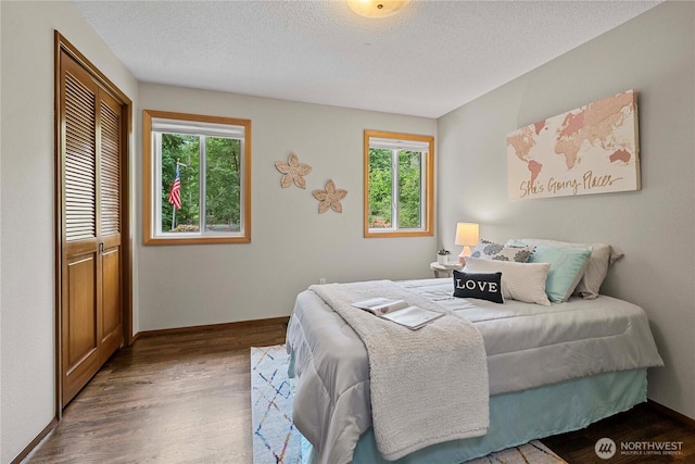 29701 52nd Ave E, Graham, WA 98338 - bedroom featuring multiple windows, wood finished floors, a closet, and a textured ceiling
