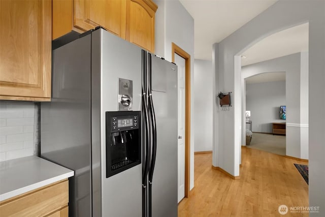 8233 NE 163rd Pl, Kenmore, WA 98028 - kitchen with stainless steel refrigerator with ice dispenser, arched walkways, backsplash, light wood-style floors, and light countertops