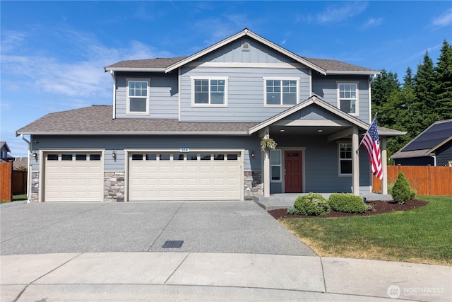 514 Wellington Pl, Sedro Woolley, WA 98284 - view of front of home with concrete driveway, a porch, stone siding, and a garage