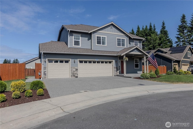 514 Wellington Pl, Sedro Woolley, WA 98284 - view of front of property featuring asphalt driveway, a garage, board and batten siding, and stone siding
