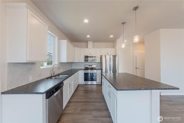 514 Wellington Pl, Sedro Woolley, WA 98284 - kitchen featuring stainless steel appliances, a center island, white cabinetry, dark wood-style floors, and decorative backsplash