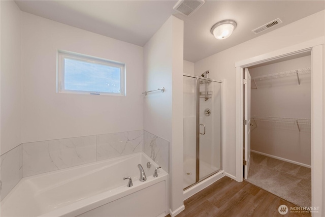 514 Wellington Pl, Sedro Woolley, WA 98284 - bathroom featuring a shower stall, a bath, a walk in closet, and wood finished floors