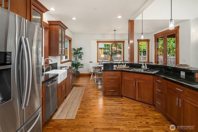 10904 W Lake Joy Dr NE, Carnation, WA 98014 - kitchen with appliances with stainless steel finishes, light wood finished floors, hanging light fixtures, recessed lighting, and brown cabinetry