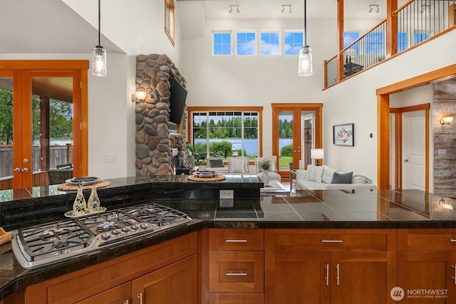 10904 W Lake Joy Dr NE, Carnation, WA 98014 - kitchen featuring open floor plan, brown cabinetry, a high ceiling, tile counters, and french doors
