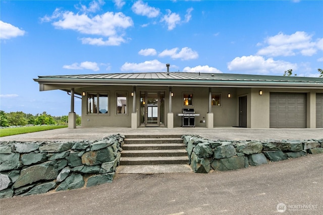 1409 Marietta Ave, Bellingham, WA 98226 - view of front facade featuring a standing seam roof, stucco siding, covered porch, a metal roof, and a garage