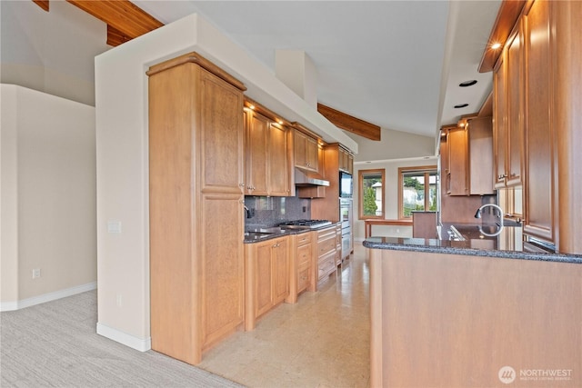 1409 Marietta Ave, Bellingham, WA 98226 - kitchen with under cabinet range hood, decorative backsplash, dark stone countertops, stainless steel gas cooktop, and a peninsula