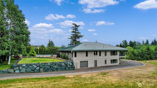 1409 Marietta Ave, Bellingham, WA 98226 - back of house with a metal roof, a lawn, stucco siding, a standing seam roof, and a garage