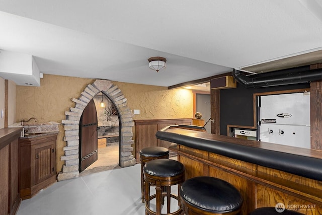 4628 Sunnyside Ave N, Seattle, WA 98103 - indoor bar with a wainscoted wall, concrete floors, a textured wall, and wooden walls