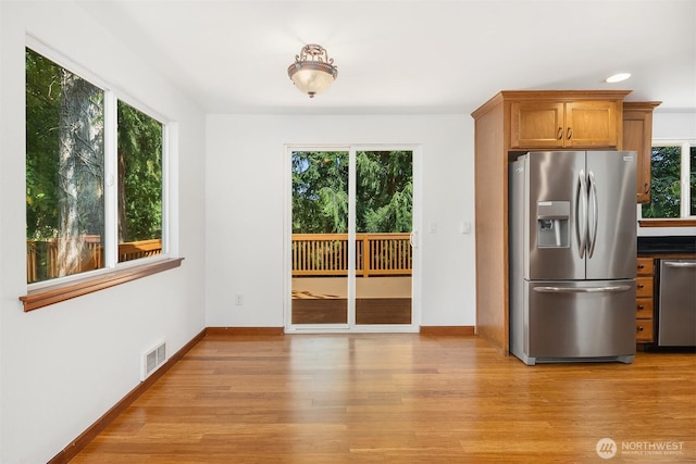 21310 SE 412th Pl, Enumclaw, WA 98022 - kitchen featuring appliances with stainless steel finishes, plenty of natural light, brown cabinetry, and light wood-style flooring