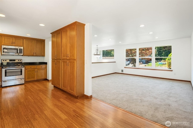 21310 SE 412th Pl, Enumclaw, WA 98022 - kitchen with stainless steel appliances, brown cabinets, recessed lighting, dark countertops, and light wood-type flooring