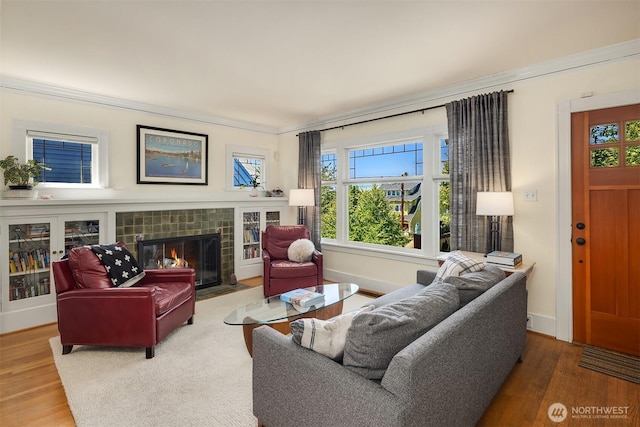 103 NW 62nd St, Seattle, WA 98107 - living area featuring wood finished floors, healthy amount of natural light, a fireplace, and crown molding