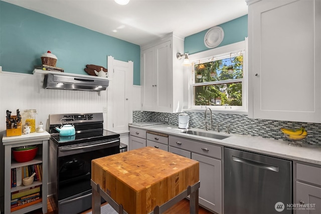 103 NW 62nd St, Seattle, WA 98107 - kitchen with stainless steel dishwasher, electric range oven, extractor fan, gray cabinets, and a wainscoted wall