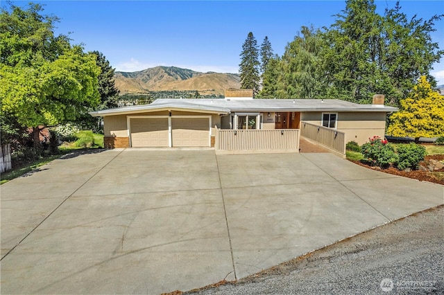 1840 Country Club Dr, East Wenatchee, WA 98802 - view of front facade with a mountain view, an attached garage, driveway, and a chimney