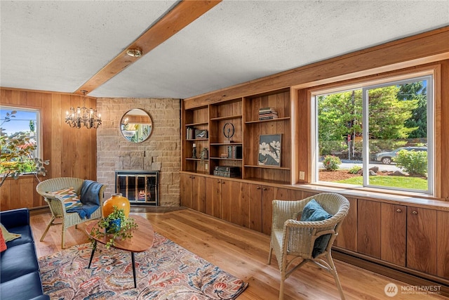 1840 Country Club Dr, East Wenatchee, WA 98802 - living area with wood walls, a stone fireplace, beamed ceiling, light wood-style flooring, and a textured ceiling