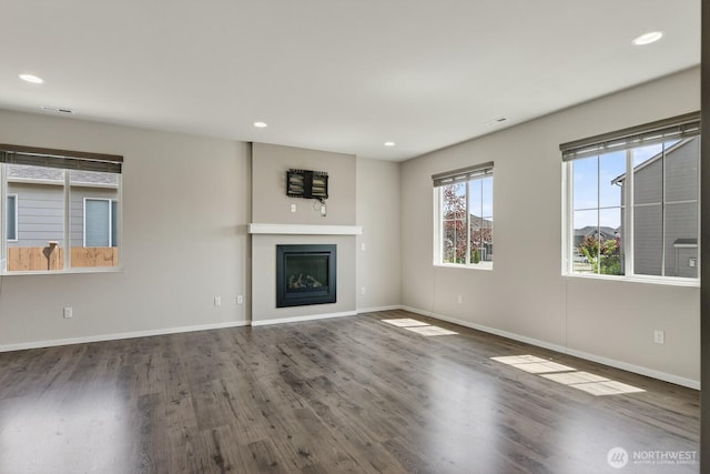 6729 283rd Pl NW, Stanwood, WA 98292 - unfurnished living room featuring wood finished floors, a glass covered fireplace, and recessed lighting