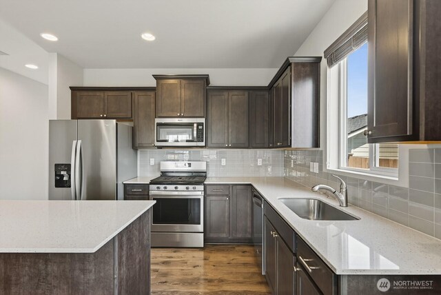 6729 283rd Pl NW, Stanwood, WA 98292 - kitchen featuring appliances with stainless steel finishes, dark brown cabinets, light stone countertops, and recessed lighting
