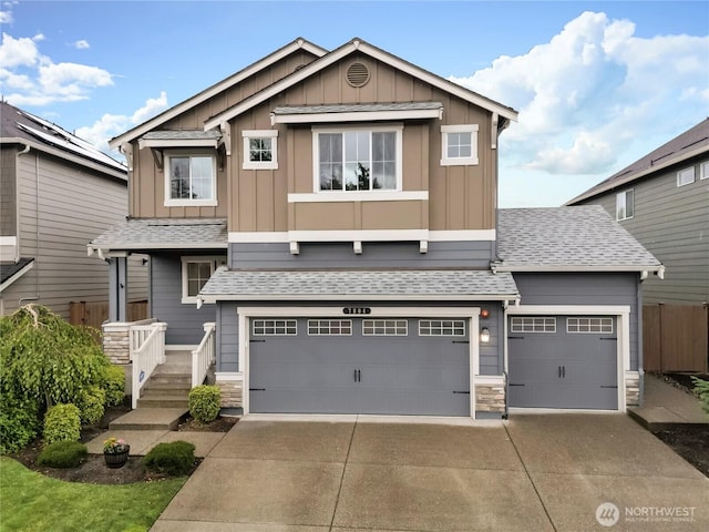 7804 208th Ave E, Bonney Lake, WA 98391 - view of front facade with board and batten siding, driveway, stone siding, and an attached garage