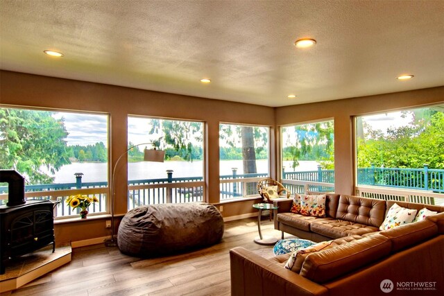 6601 27th Ln SE, Lacey, WA 98503 - living room with a wood stove, a water view, recessed lighting, wood finished floors, and a textured ceiling