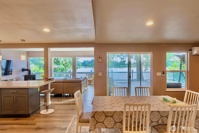 6601 27th Ln SE, Lacey, WA 98503 - dining area with light wood-style flooring, a wood stove, plenty of natural light, recessed lighting, and a wall mounted AC