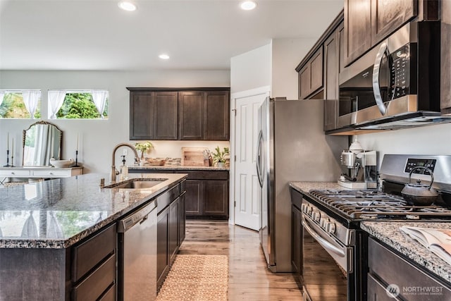 2726 Kacie Ct NE, Lacey, WA 98516 - kitchen with appliances with stainless steel finishes, light wood finished floors, stone counters, dark brown cabinetry, and recessed lighting