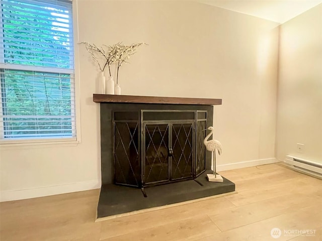 147 S 329th Pl Unit A, Federal Way, WA 98003 - detailed view of wood finished floors, a fireplace with raised hearth, and a baseboard heating unit