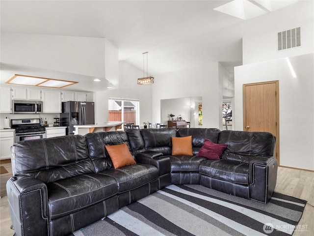 5415 Komachin Loop SE, Lacey, WA 98513 - living room with light wood-style flooring, high vaulted ceiling, and a skylight