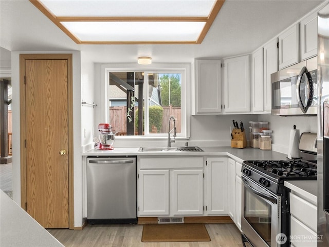 5415 Komachin Loop SE, Lacey, WA 98513 - kitchen featuring stainless steel appliances, light wood-style flooring, light countertops, and white cabinets