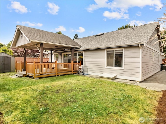 5415 Komachin Loop SE, Lacey, WA 98513 - rear view of house with a storage unit, a wooden deck, a lawn, and roof with shingles