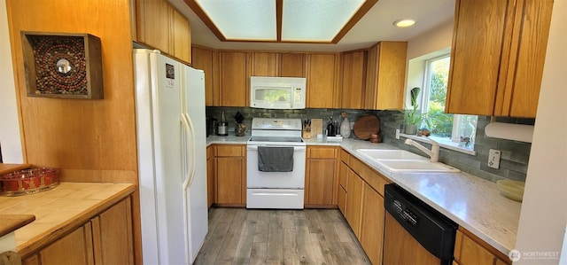 2904 271st St, Ocean Park, WA 98640 - kitchen with white appliances, light wood-style floors, decorative backsplash, brown cabinetry, and recessed lighting