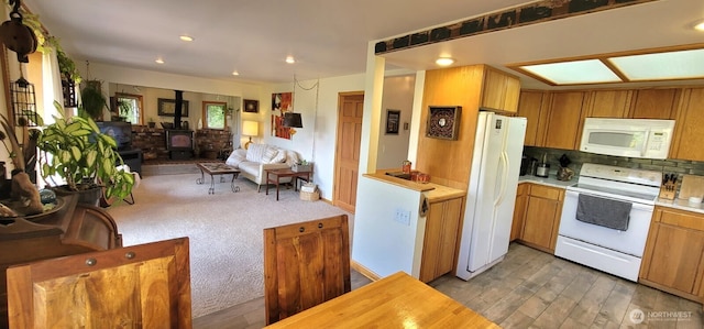 2904 271st St, Ocean Park, WA 98640 - kitchen with white appliances, a wood stove, light countertops, tasteful backsplash, and open floor plan