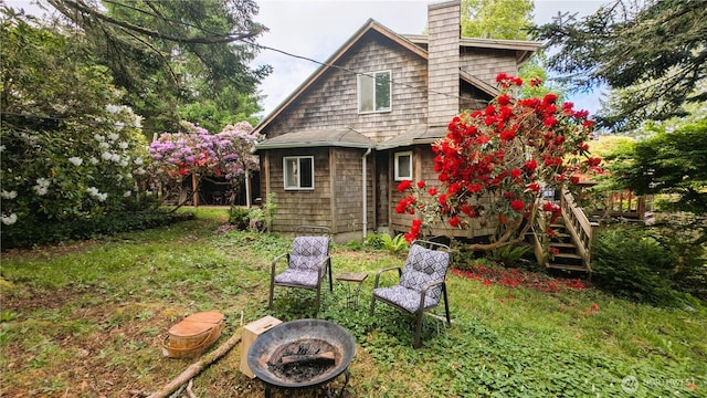 2904 271st St, Ocean Park, WA 98640 - back of property featuring an outdoor fire pit, a chimney, a deck, and a yard