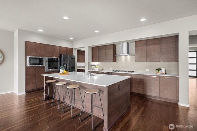 13506 196th Ave SE, Monroe, WA 98272 - kitchen with stainless steel appliances, modern cabinets, wall chimney range hood, a kitchen breakfast bar, and recessed lighting