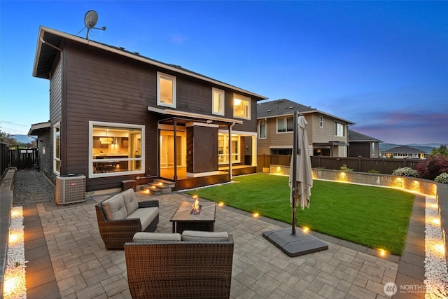 13506 196th Ave SE, Monroe, WA 98272 - back of house at dusk featuring a patio area, an outdoor living space with a fire pit, and a fenced backyard