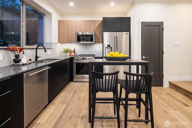 9047 Dibble Ave NW Unit C, Seattle, WA 98117 - kitchen featuring appliances with stainless steel finishes, modern cabinets, dark cabinetry, and recessed lighting