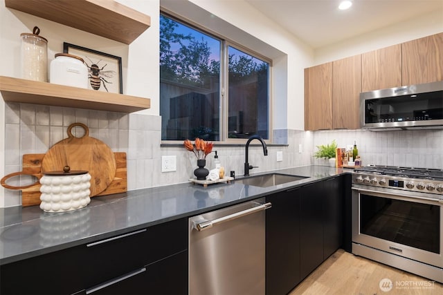9047 Dibble Ave NW Unit C, Seattle, WA 98117 - kitchen featuring stainless steel appliances, modern cabinets, dark cabinetry, tasteful backsplash, and recessed lighting