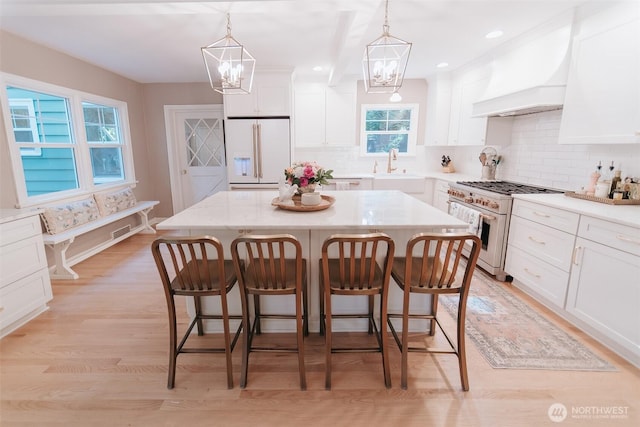 1325 SW 120th St, Burien, WA 98146 - kitchen with stainless steel stove, white fridge with ice dispenser, a breakfast bar, a chandelier, and white cabinets