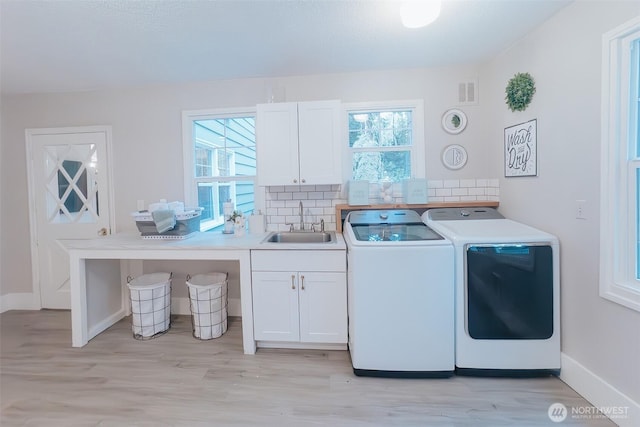 1325 SW 120th St, Burien, WA 98146 - laundry room with washing machine and dryer, cabinet space, light wood-style floors, and plenty of natural light