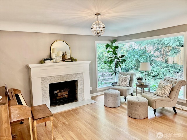 1325 SW 120th St, Burien, WA 98146 - living area featuring wood finished floors, a fireplace with flush hearth, and a chandelier