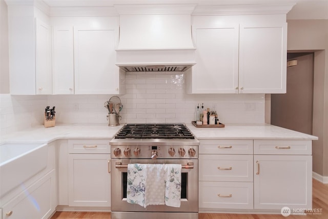 1325 SW 120th St, Burien, WA 98146 - kitchen featuring stainless steel range, premium range hood, backsplash, white cabinets, and light stone counters